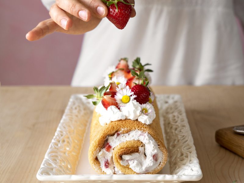 bolo-saboroso-de-alto-angulo-com-morangos-na-mesa